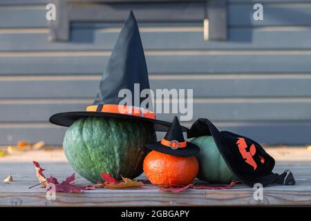 Tre zucche di Halloween in cappelli di strega su una terrazza di legno Foto Stock