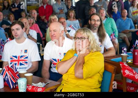 La famiglia e gli amici della medaglia d'oro olimpica Eilidh McIntyre, la sua fidanzata Jonny Forer (a sinistra), il padre Mike McIntyre e la madre Caroline McIntyre che guardano sul grande schermo al Hayling Island Sailing Club, Hampshire, mentre compete nei Giochi Olimpici di Tokyo 2020. Data immagine: Mercoledì 4 agosto 2021. Foto Stock