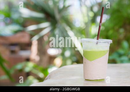 frullato di tè verde matcha su sfondo verde Foto Stock
