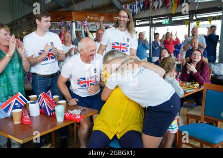 La famiglia della medaglia d'oro olimpica Eilidh McIntyre festeggia all'Hayling Island Sailing Club, Hampshire, mentre la sua barca passa il traguardo nei Giochi Olimpici di Tokyo 2020. Data immagine: Mercoledì 4 agosto 2021. Foto Stock