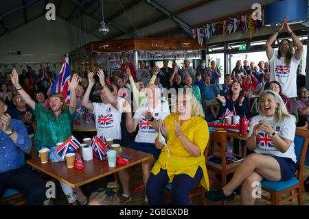 La famiglia e gli amici della medaglia d'oro olimpica Eilidh McIntyre festeggiano all'Hayling Island Sailing Club, Hampshire, mentre la sua barca attraversa il traguardo ai Giochi Olimpici di Tokyo 2020. Data immagine: Mercoledì 4 agosto 2021. Foto Stock