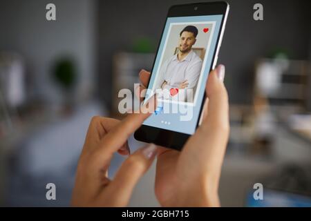 Female dito premere il pulsante chat sullo smartphone utilizzando l'app di incontri per trovare l'amore Foto Stock