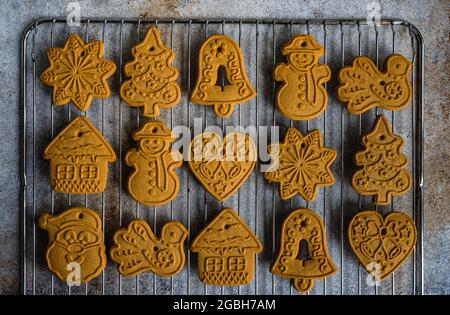 Biscotti assortiti di pan di zenzero di Natale su una griglia di raffreddamento di metallo Foto Stock
