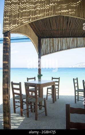 Tradizionale taverna greca, isola di Koufonisi, Grecia semplice ristorante sul mare vicino alla spiaggia. Shot verticale. Nessuna gente. Sfondo sfocato con copie s. Foto Stock