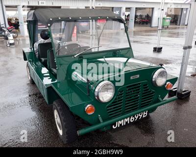 Tre quarti di vista frontale di un Green, 1964, Morris Mini moke, coperta, nel Paddock Nazionale, al Silverstone Classic 2021 Foto Stock