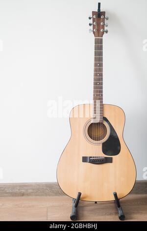 La chitarra acustica si trova sullo stand dell'appartamento Foto Stock