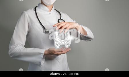 Medico femminile che tiene in mano la ghiandola tiroidea virtuale. Organo umano Handrawn, spazio di copia sul lato destro, colori di foto grezzi. Servizio sanitario ospedaliero con Foto Stock