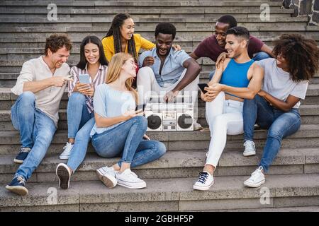 Giovani diverse persone che si divertono ad ascoltare musica con stereo stereo stereo Boombox all'aperto in città - Focus Center african Girl Face Foto Stock