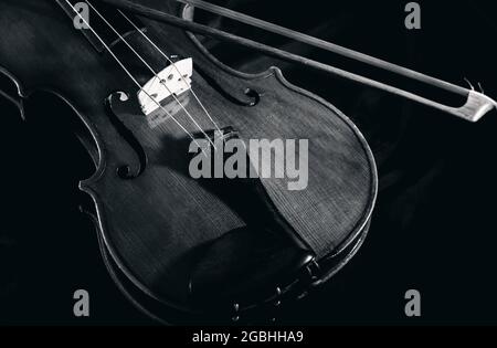 Violino con arco di violino su sfondo nero, primo piano, isolato Foto Stock