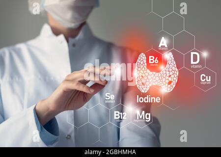 Sostanze nutritive essenziali per la salute della ghiandola tiroidea, tra cui iodio, Selenuim, vitamina B6, Cuprum. Ritratto offuscato del medico che tiene evidenziato Thyro rosso Foto Stock