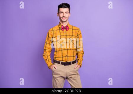 Foto di giovane bell'uomo felice positivo sorriso sicuro mani fresche in tasca isolato su sfondo di colore viola Foto Stock