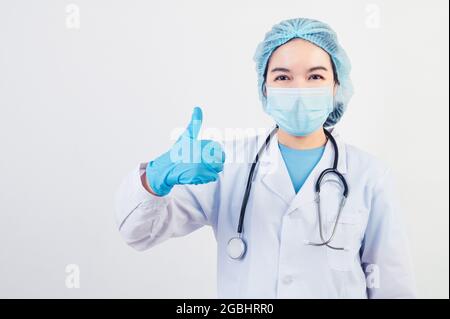 I medici professionisti danno i pollici grandi in su gesto su sfondo bianco ai pazienti che hanno trattato all'ospedale o alla clinica per assicurare che otterranno presto. Medica Foto Stock