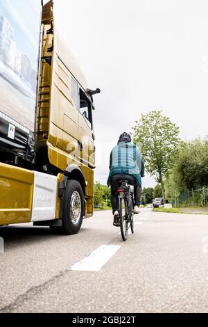 Schweitenkirchen, Germania. 04 agosto 2021. Un ciclista passa accanto a un veicolo con specchietti retrovisori esterni digitali durante un evento di stampa per dimostrare il sistema di sostituzione digitale degli specchietti "MAN OptiView". MAN, produttore di veicoli industriali, vuole ridurre il numero di incidenti in curva con un nuovo assistente digitale dei punti ciechi che sostituisce gli specchietti tradizionali con telecamere e display. Credit: Attias Balk/dpa/Alamy Live News Foto Stock