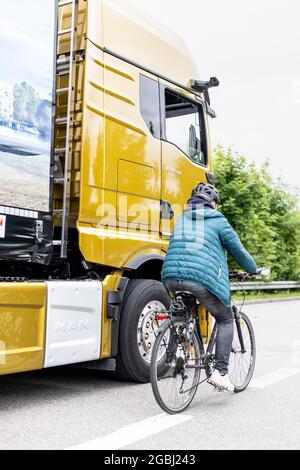 Schweitenkirchen, Germania. 04 agosto 2021. Un ciclista passa accanto a un veicolo con specchietti retrovisori esterni digitali durante un evento di stampa per dimostrare il sistema di sostituzione digitale degli specchietti "MAN OptiView". MAN, produttore di veicoli industriali, vuole ridurre il numero di incidenti in curva con un nuovo assistente digitale dei punti ciechi che sostituisce gli specchietti tradizionali con telecamere e display. Credit: Attias Balk/dpa/Alamy Live News Foto Stock