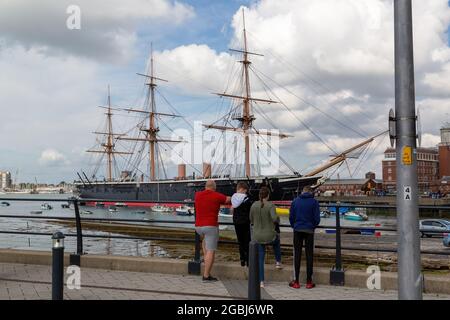 08-04-2021 Portsmouth, Hampshire, UK una famiglia che guarda la vista verso HMS Warrior è nato a Portsmouth, Regno Unito Foto Stock