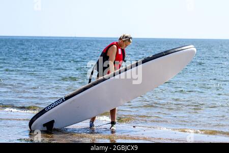 Dundee, Tayside, Scozia, Regno Unito. 4 agosto 2021. Regno Unito Meteo: Caldo e soleggiato a Dundee con temperature che raggiungono i 21°C. Un paddleboarder femminile che si gode le vacanze estive di agosto prende la giornata a paddleboard sul fiume Tay presso la spiaggia Broughty Ferry. Credit: Dundee Photographics/Alamy Live News Foto Stock