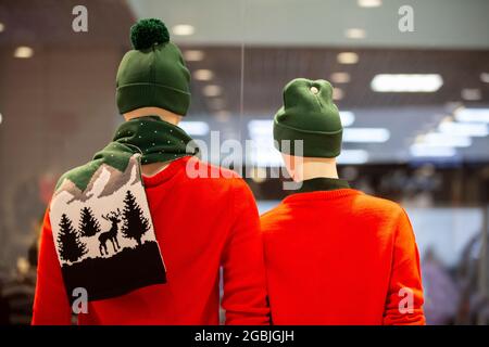 I manichini di un uomo in abiti rossi d'inverno si levano con le loro spalle. Concetto di vendita per l'anno nuovo. Foto Stock