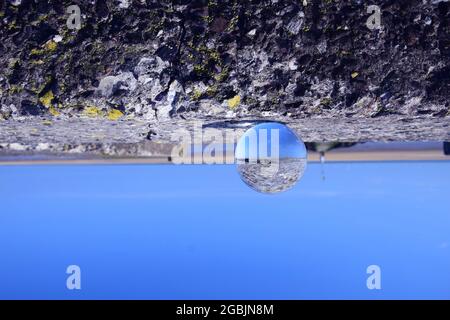 La marea si trova sulla riva dell'estuario del Mersey e mostra le rive di sabbia esposte, gli uccelli marini, il fiume Alt affluente sotto il cielo blu e la luce solare estiva. Foto Stock