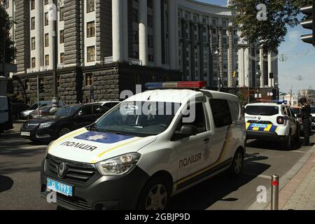 KIEV, UCRAINA - 4 AGOSTO 2021 - le auto della polizia di pattuglia sono parcheggiate fuori del palazzo del governo dei ministri durante l'operazione speciale della polizia per detenere un uomo che minaccia di mettere fuori una granata di mano all'interno del quartier generale del governo, Kyiv, capitale dell'Ucraina. Mercoledì, alle ore 10 circa, ora locale, un uomo con una granata a mano con un perno tirato è entrato nell'edificio del Gabinetto dei Ministri minacciando di bruciarlo. Dopo brevi negoziati, il colpevole che si ritiene essere un veterano di guerra di Donbas con la sindrome post-concussione è stato rapito. Foto Stock