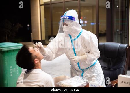 (210804) -- ZHANGJIAJIE, 4 agosto 2021 (Xinhua) -- UN medico prende un campione di tampone da un residente per il test di acido nucleico COVID-19 a Zhangjiajie, provincia di Hunan della Cina centrale, 4 agosto 2021. Zhangjiajie, città della Cina centrale, che ha riportato un gruppo di recenti infezioni COVID-19 del paese, aveva completato due cicli di test di acido nucleico tutto compreso a partire da martedì, le autorità locali hanno detto. Più di 809,000 persone sono state campionate da quando la città ha lanciato il suo primo ciclo di test di massa il 29 luglio, ha detto il quartier generale comunale sulla prevenzione e il controllo COVID-19 durante un pre Foto Stock