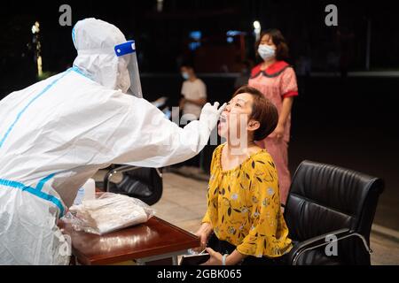 (210804) -- ZHANGJIAJIE, 4 agosto 2021 (Xinhua) -- UN medico prende un campione di tampone da un residente per il test di acido nucleico COVID-19 a Zhangjiajie, provincia di Hunan della Cina centrale, 4 agosto 2021. Zhangjiajie, città della Cina centrale, che ha riportato un gruppo di recenti infezioni COVID-19 del paese, aveva completato due cicli di test di acido nucleico tutto compreso a partire da martedì, le autorità locali hanno detto. Più di 809,000 persone sono state campionate da quando la città ha lanciato il suo primo ciclo di test di massa il 29 luglio, ha detto il quartier generale comunale sulla prevenzione e il controllo COVID-19 durante un pre Foto Stock