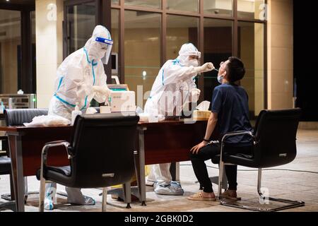 (210804) -- ZHANGJIAJIE, 4 agosto 2021 (Xinhua) -- UN medico prende un campione di tampone da un residente per il test di acido nucleico COVID-19 a Zhangjiajie, provincia di Hunan della Cina centrale, 4 agosto 2021. Zhangjiajie, città della Cina centrale, che ha riportato un gruppo di recenti infezioni COVID-19 del paese, aveva completato due cicli di test di acido nucleico tutto compreso a partire da martedì, le autorità locali hanno detto. Più di 809,000 persone sono state campionate da quando la città ha lanciato il suo primo ciclo di test di massa il 29 luglio, ha detto il quartier generale comunale sulla prevenzione e il controllo COVID-19 durante un pre Foto Stock