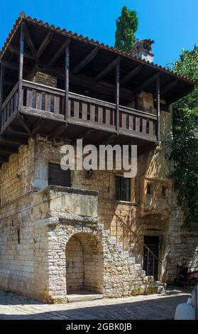 Un antico edificio romanico in pietra e legno nella storica città costiera medievale di Porec in Istria, Croazia. Risale alla metà del 13 ° secolo e esso Foto Stock