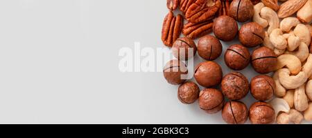 Pecan, noci brasiliane, anacardi, mandorle e noci di macadamia. Corretta composizione nutrizionale di assortiti NUTS modello verticale foto su sfondo grigio. Piatto Foto Stock