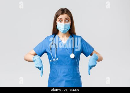 Covid-19, prevenzione di virus, salute, operatori sanitari e concetto di quarantena. Entusiasta ed interessata dottore, infermiera in scrub blu e medico Foto Stock