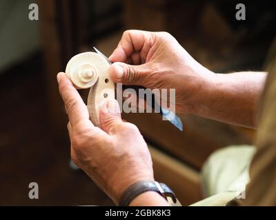 Luthier che lavora sulla testa del violino e sul ricciolo Foto Stock