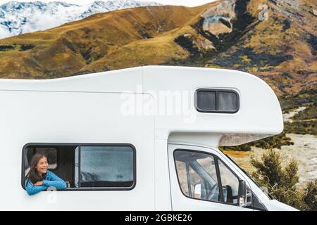 RV viaggio donna turistica strada guardando fuori la finestra del suo camper in Nuova Zelanda viaggio. Felice giovane ragazza asiatica che viaggia all'aperto in avventura Foto Stock