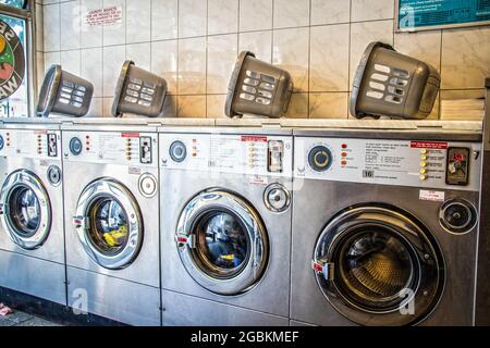 2019 07 23  lavanderia o terrecotte con lavatrici a caricamento frontale a gettoni e cestini landry sulla parte superiore Foto Stock