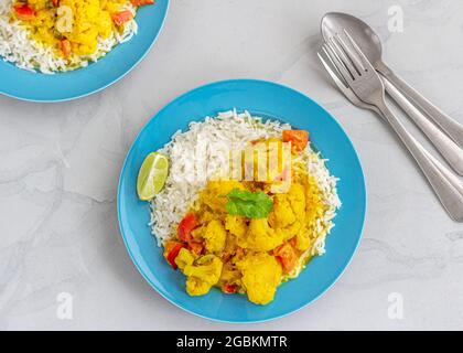 Thai Vegan Cauliflower Curry con riso in un piatto guarnito con Cilantro direttamente sopra orizzontale Foto Foto Stock