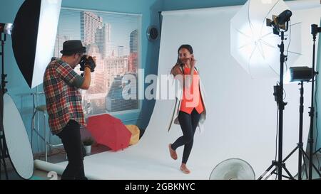 Bellissimo modello sorridente di etnia africana che si pone per un fotografo in studio moderno foto sparare. Foto scattate per una rivista di moda elegante. Foto Stock