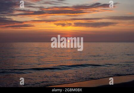 Bellissimo tramonto sul mare con romantico cielo colorato fotografato dalla spiaggia olandese di Schoorl Foto Stock