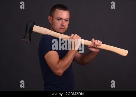 un uomo con una grande ascia per tritare il legno Foto Stock