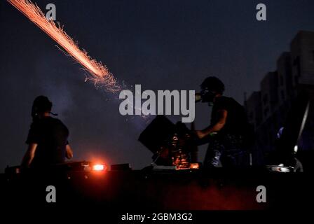 Beirut, Libano. 04 agosto 2021. Un incendio di polizia in rivolta strappa bombe a gas contro i manifestanti anti del governo durante gli scontri in uno degli ingressi del Parlamento libanese dopo una marcia per celebrare il 1° anniversario della massiccia esplosione del porto di Beirut dell'agosto 2020. Il 04 agosto 2020, una grande quantità di nitrato di ammonio immagazzinato nel porto di Beirut è scese, uccidendo almeno 218 persone e ferendone altre 7,500. Credit: Marwan Naamani/dpa/Alamy Live News Foto Stock