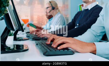 Media dose di operatori mani digitando sulla tastiera in ufficio moderno. Le persone sono occupate a lavorare sul computer. Foto Stock