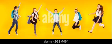 il gruppo di scolari diversi saltano e agitando le mani Foto Stock