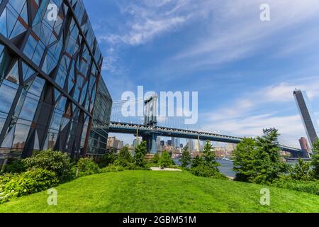 Il Manhattan Bridge si erge oltre l'East River dal Lawn of the Brooklyn Bridge Park, nel mezzo di Pandemic of COVID-19 il 20 giugno 2021 a New York City, USA Foto Stock