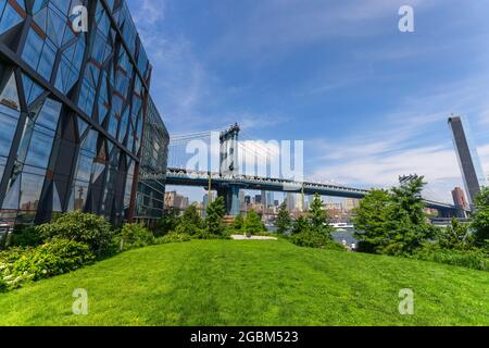 Il Manhattan Bridge si erge oltre l'East River dal Lawn of the Brooklyn Bridge Park, nel mezzo di Pandemic of COVID-19 il 20 giugno 2021 a New York City, USA Foto Stock