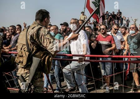 Beirut, Libano. 04 agosto 2021. Un soldato libanese si scuote con i manifestanti che cercano di raggiungere il porto per partecipare a una cerimonia per celebrare il 1 ° anniversario della massiccia esplosione di Beirut agosto 2020. Il 04 agosto 2020, una grande quantità di nitrato di ammonio immagazzinato nel porto di Beirut è scese, uccidendo almeno 218 persone e ferendone altre 7,500. Credit: Marwan Naamani/dpa/Alamy Live News Foto Stock