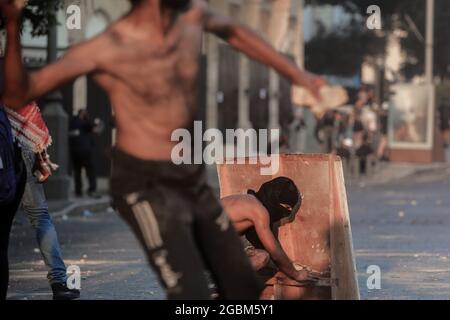 Beirut, Libano. 04 agosto 2021. I manifestanti anti anti anti-governativi si scontrano con la polizia antisommossa e i soldati dell'esercito libanese ad una delle entrate del Parlamento libanese dopo una marcia per celebrare il 1° anniversario della massiccia esplosione del porto di Beirut dell'agosto 2020. Il 04 agosto 2020, una grande quantità di nitrato di ammonio immagazzinato nel porto di Beirut è scese, uccidendo almeno 218 persone e ferendone altre 7,500. Credit: Marwan Naamani/dpa/Alamy Live News Foto Stock