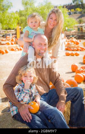 Adorabili giovane famiglia gode di una giornata presso la Zucca Patch. Foto Stock