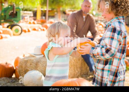 Adorabili giovane famiglia gode di una giornata presso la Zucca Patch. Foto Stock