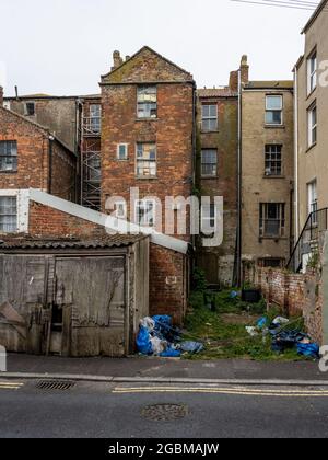 Case di città derelict con finestre fracassate si trovano sulla Esplanade di Burnham-on-Sea nel Somerset. Foto Stock