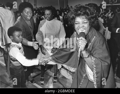 Austin, Texas USA,1988: Il cantante dei Gospel Shirley Caesar scuote le mani con un giovane fan durante lo spettacolo in un luogo pieno. ©Bob Daemmrich Foto Stock