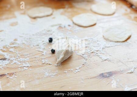 Processo di produzione di vareniki dolci con frutti di bosco tradizionale ucraino alimentare Foto Stock