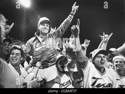 Omaha, Nebraska, USA, 1984: L'allenatore di baseball della University of Texas Cliff Gustafson viene portato fuori dal campo dai suoi giocatori dopo che UT ha vinto il campionato nazionale della College World Series. ©Bob Daemmrich Foto Stock