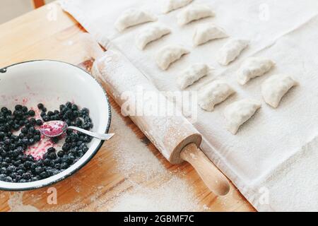 Processo di produzione di vareniki dolci con frutti di bosco tradizionale ucraino alimentare Foto Stock